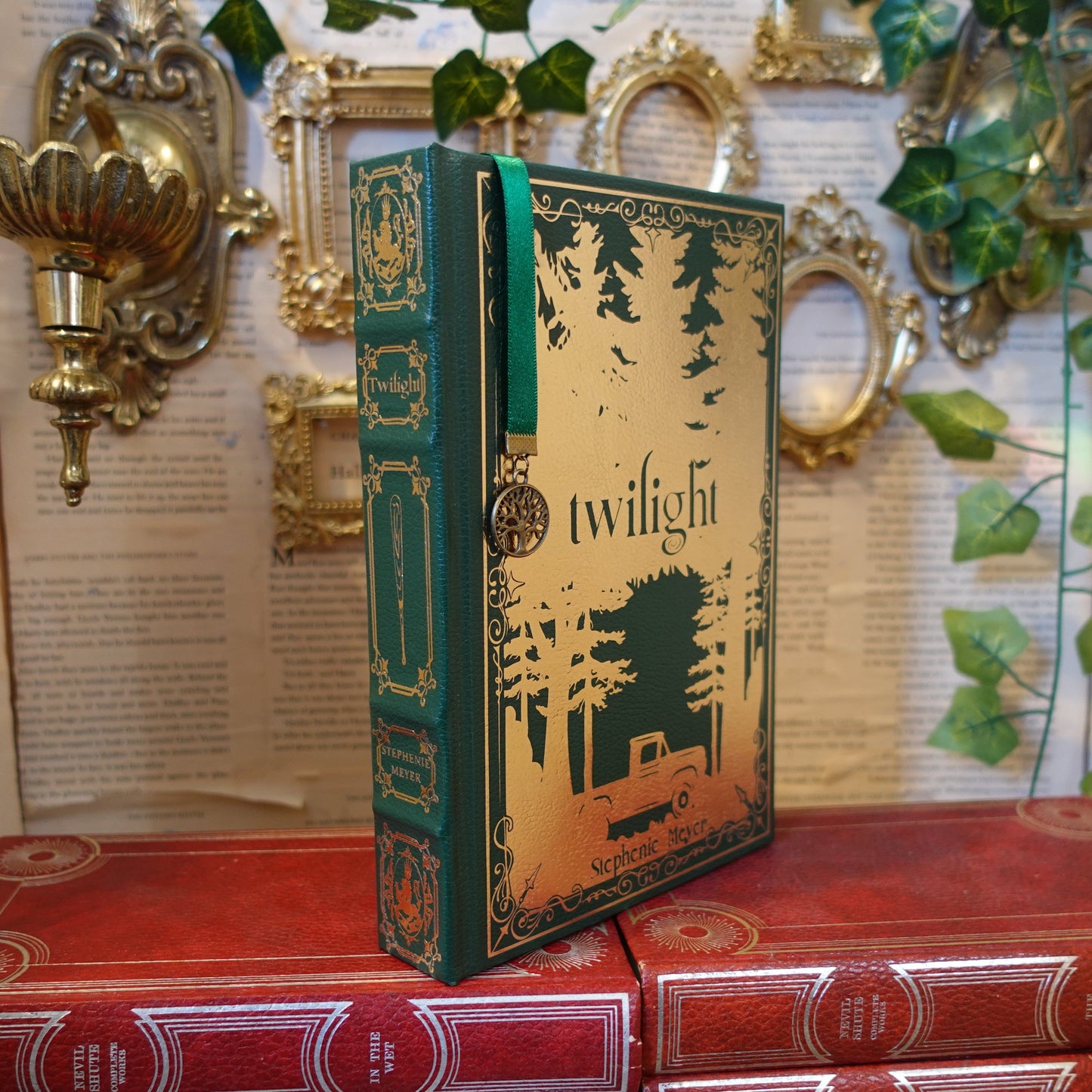 Book titled 'Twilight' on a decorative shelf with gold wall sconces and green leaves.