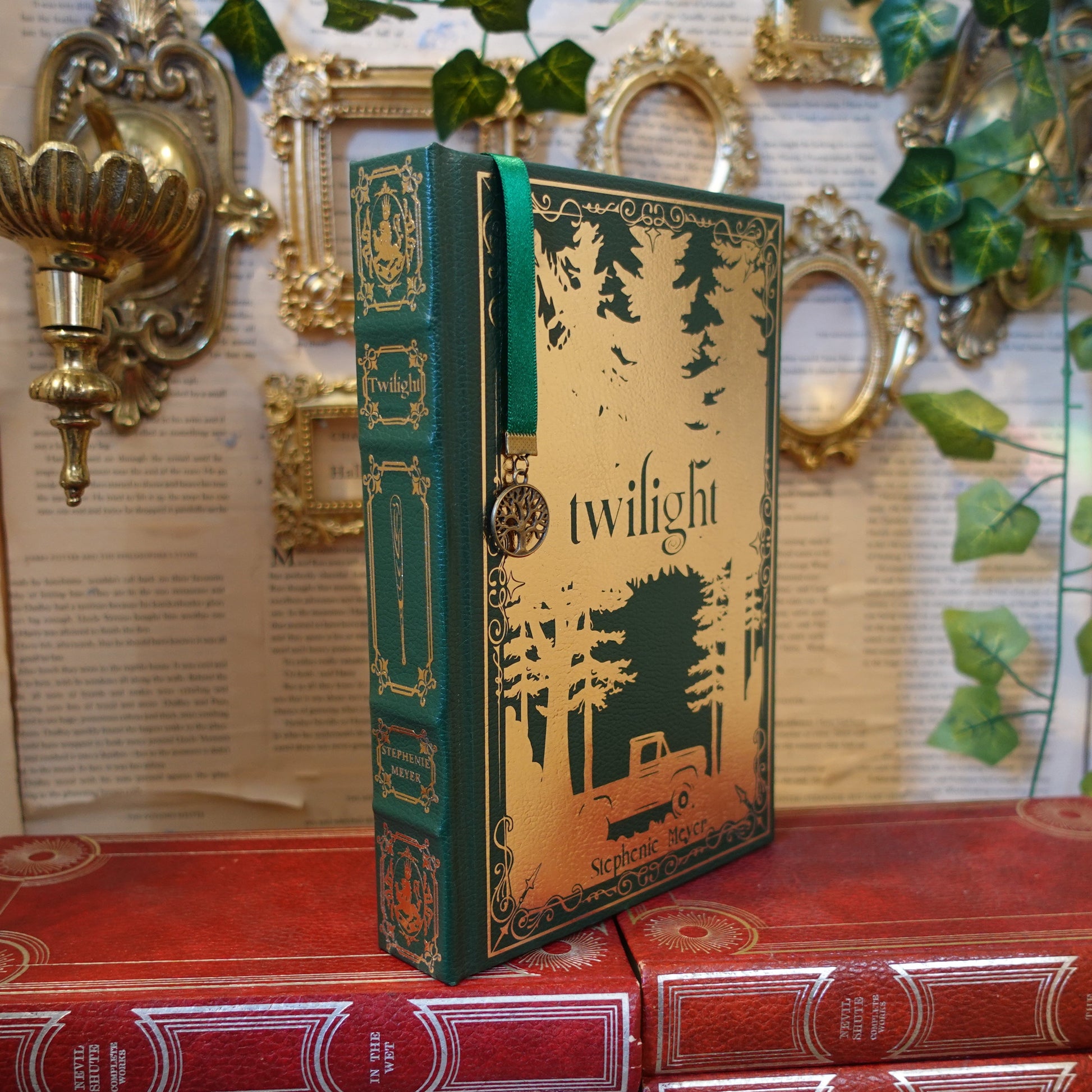 Book titled 'Twilight' on a decorative shelf with gold wall sconces and green leaves.